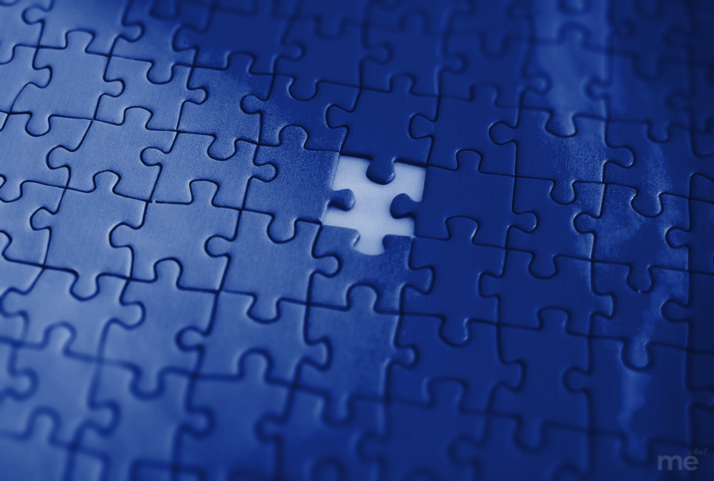 A close-up, monochromatic blue image of a completed jigsaw puzzle with one missing piece in the center, revealing a bright white space underneath.